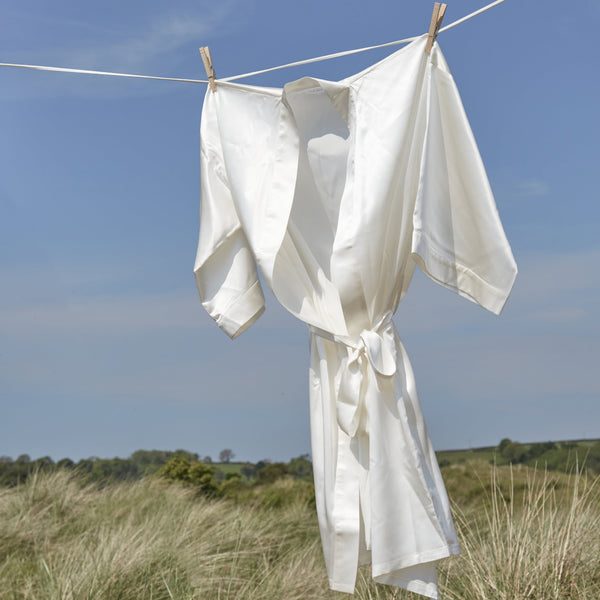 Mulberry silk ivory dressing gown hanging on a washing line in the sunshine.